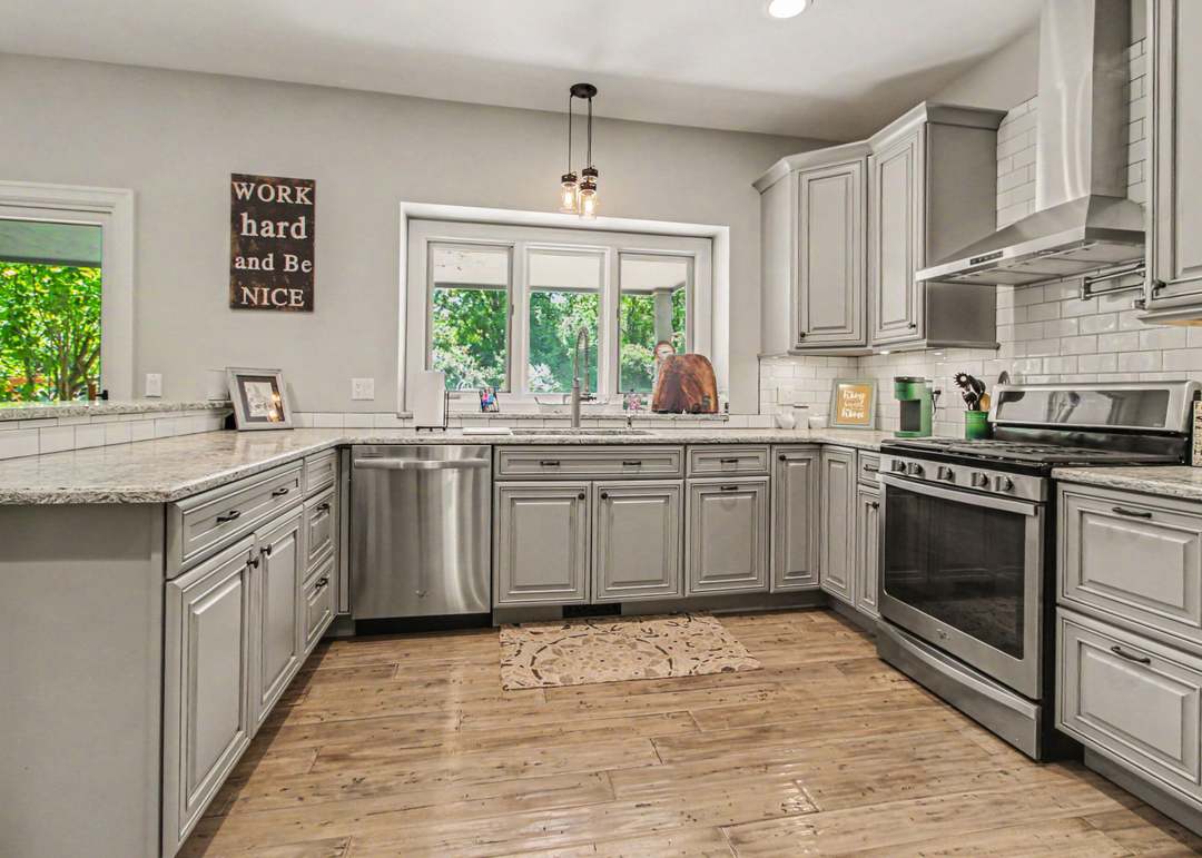 The kitchen with gray glazed Schrock cabinetry, granite counters, white subway-tile backsplash and stainless appliances.